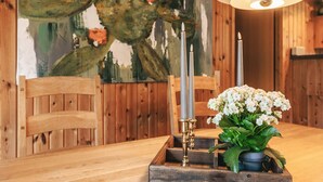 Une table de salle à manger en bois, agrémentée d’un chandelier et de fleurs.