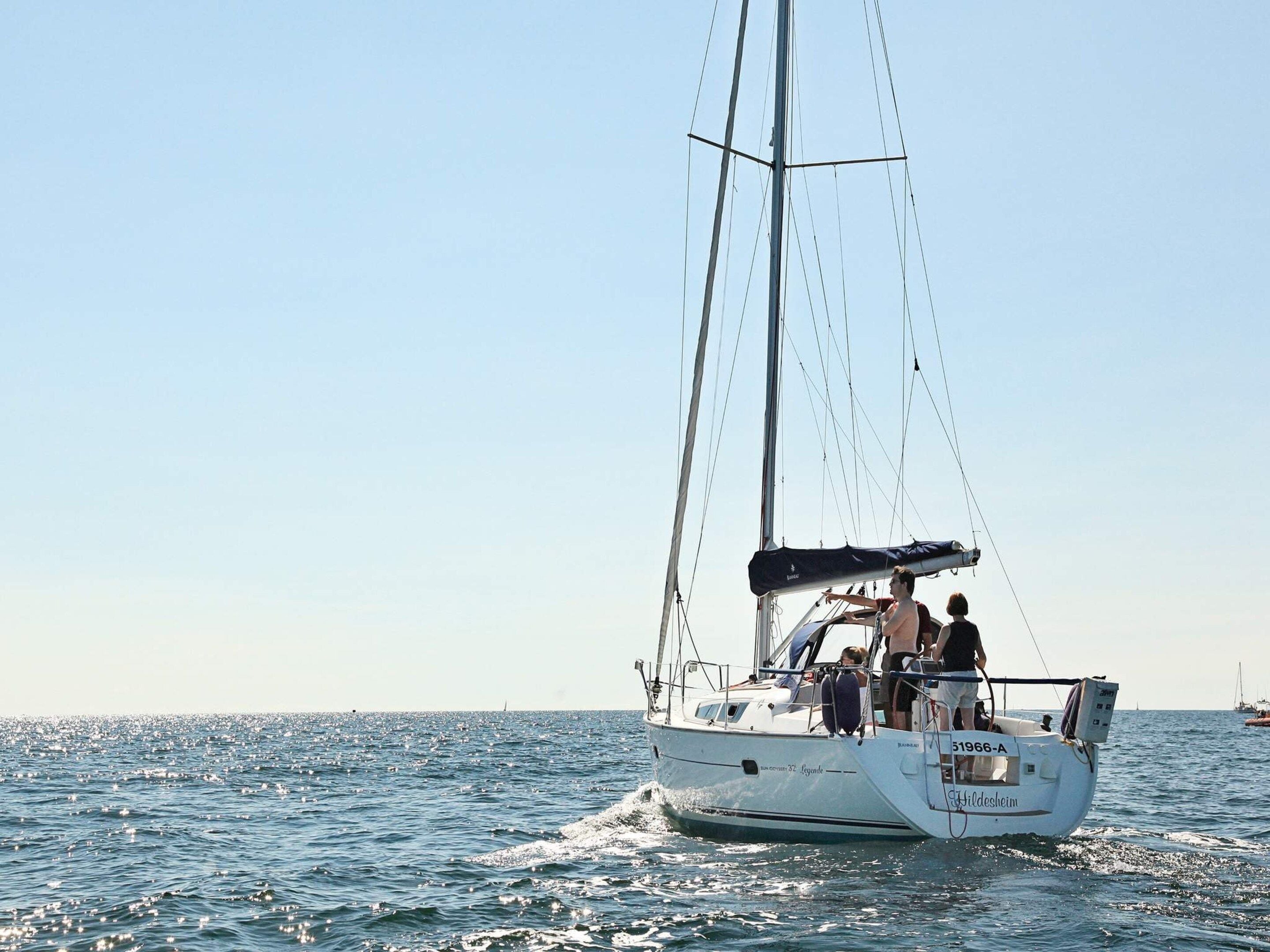 Eine Segelyacht mit Kabine und überdectem Deck fährt auf dem Wasser.