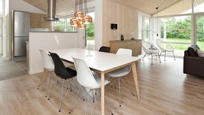 A modern kitchen with a stainless steel refrigerator, a wooden ceiling, and a dining area with a white table and chairs. - Luxury Spa Retreat by Beach - By Traum Ferienwohnungen (Glesborg)