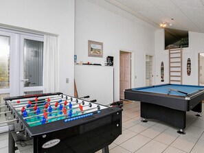 A room with a foosball table, a pool table, and a window with curtains. - 4 Star Holiday Home in Lokken (Lokken)