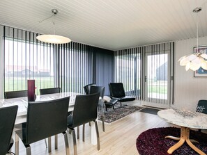 A modern dining area with a table, chairs, and a chandelier.