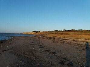 A beach with a clear sky, a sandy shore, and distant buildings. - 4 Star Holiday Home in Vinderup (Vinderup)