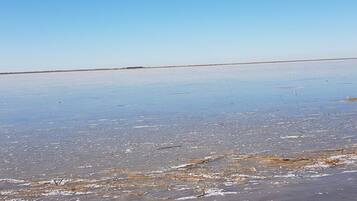 A flat, expansive salt flat with a clear sky.