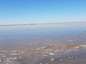 Una vasta y llana extensión salina bajo un cielo despejado.