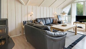 Una sala de estar acogedora con un sofá, una mesa de centro, un televisor y una chimenea.