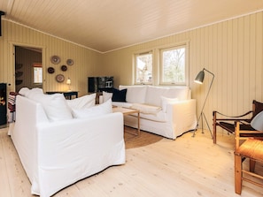Una sala de estar acogedora con un sofá blanco, piso de madera y chimenea.