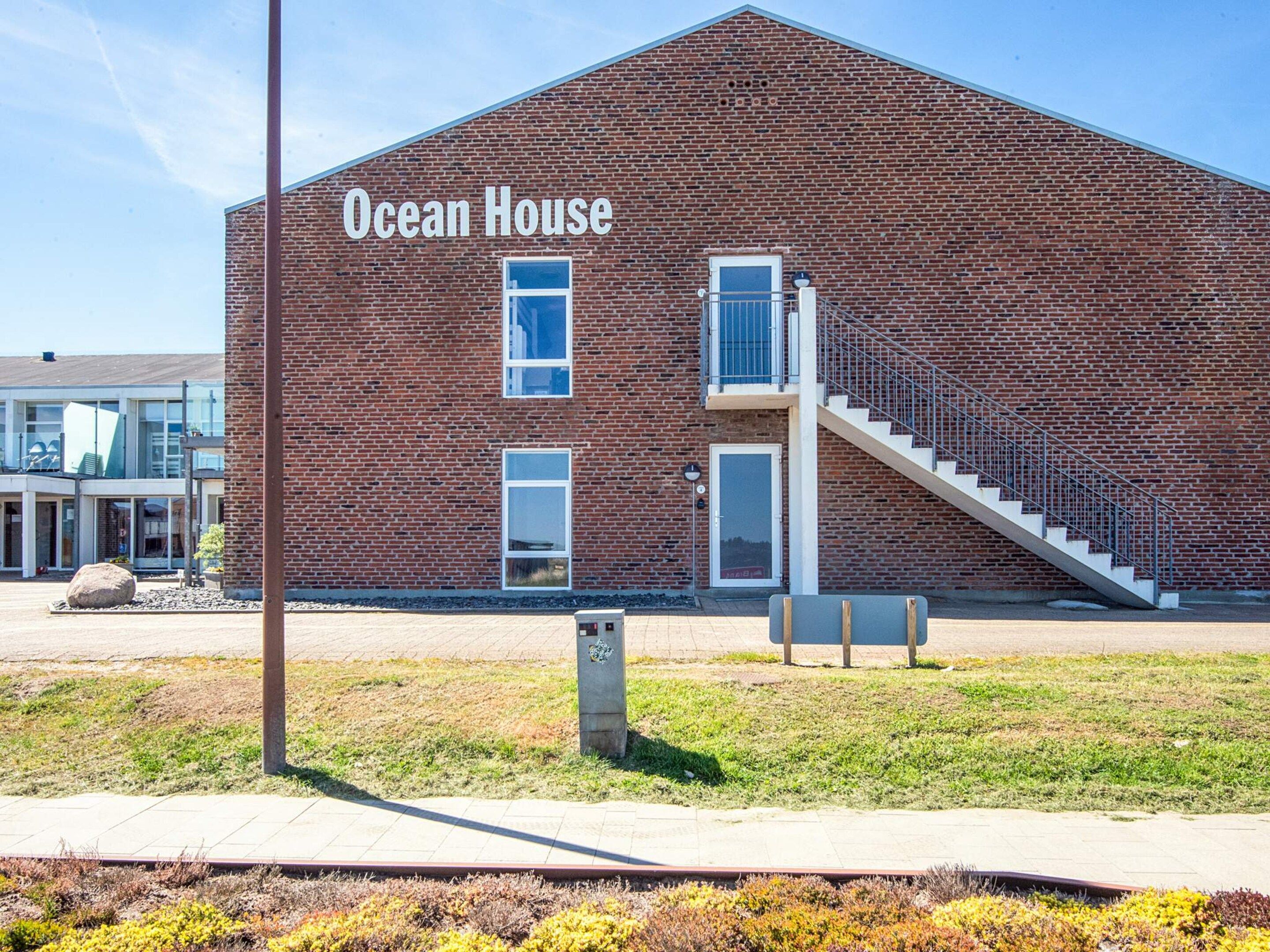 Ein Backsteinhaus mit der Aufschrift 'Ocean House' und einer Treppe, die zu einer oberen Ebene führt.