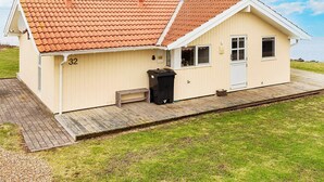 En enplansbyggnad med ett tak täckt av takpannor, en liten veranda och siffran 32 på sidan.