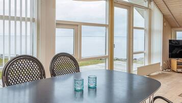 A dining area with a table, chairs, and a television.