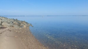 Ett lugnt område vid vattnet med en stenig strand och en klar himmel.