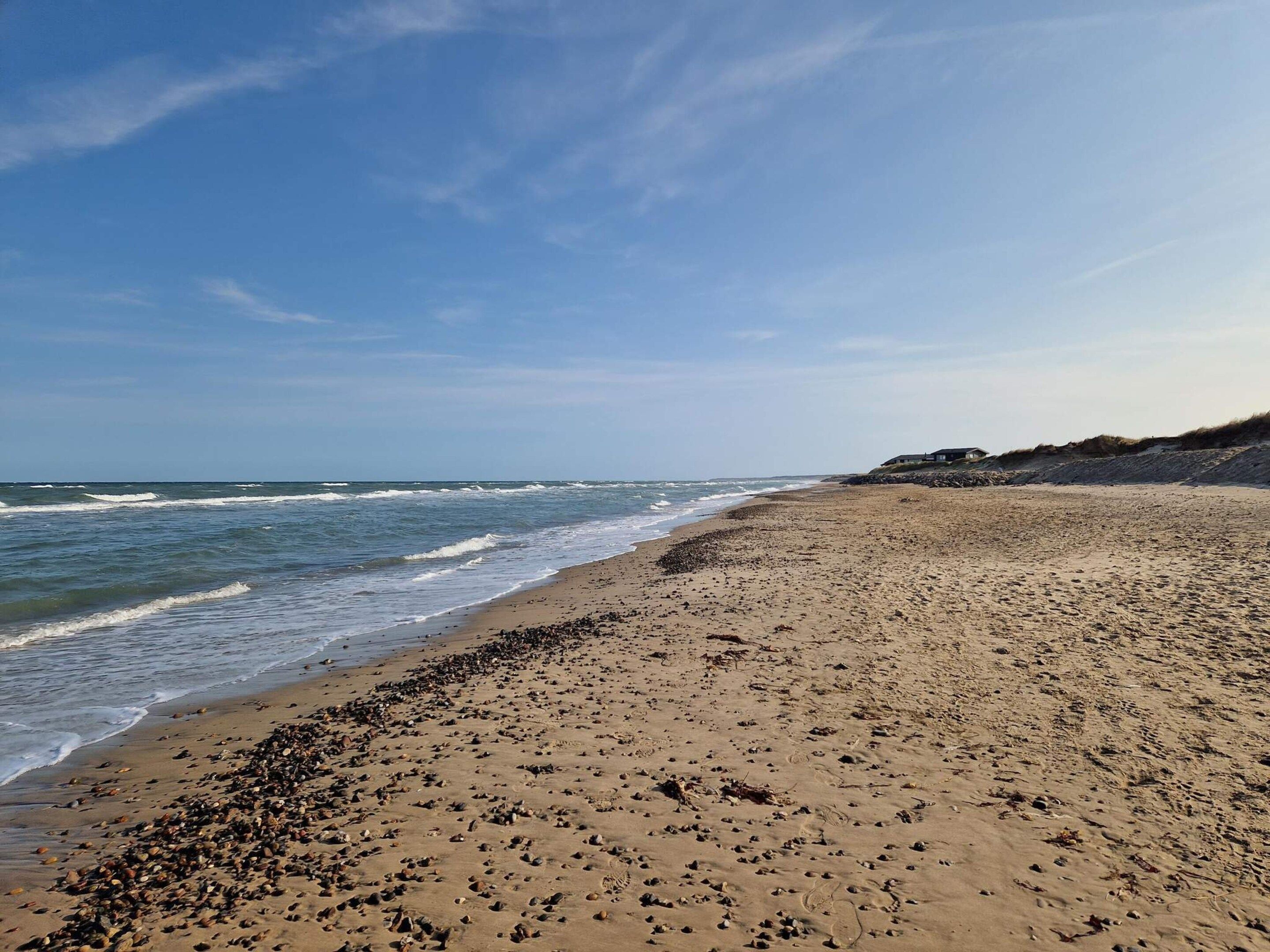 A wide sandy beach with waves crashing onto the shore.