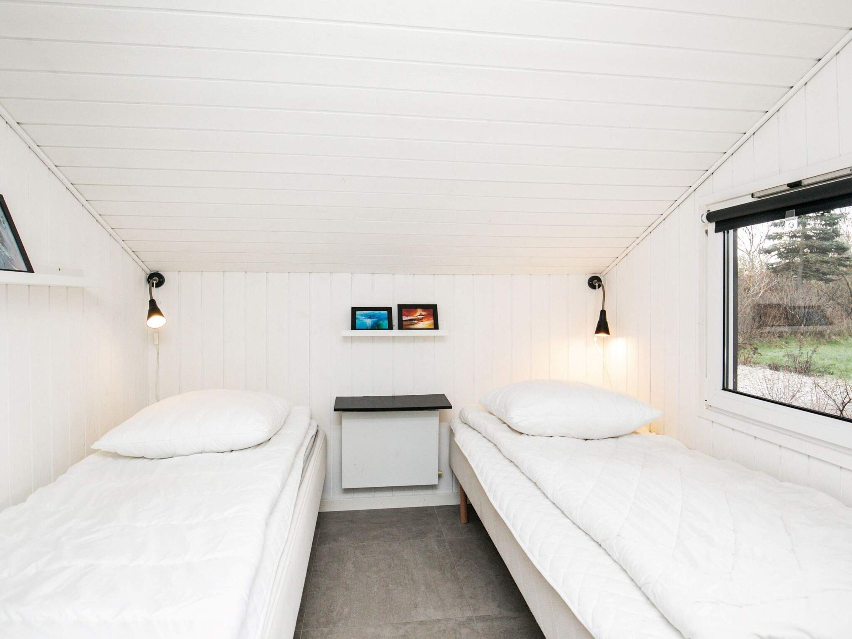 A room with two beds, a small table, and a window.