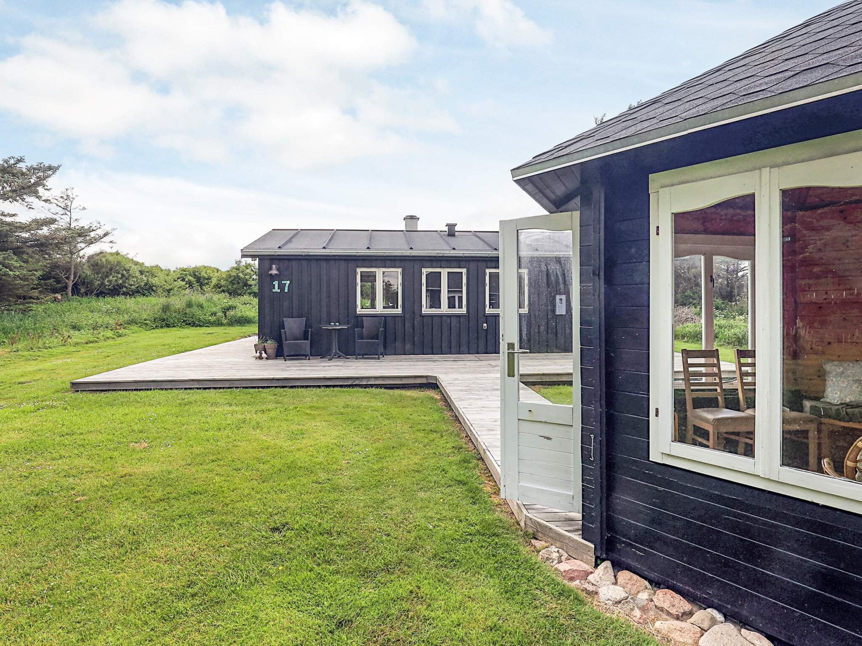 A modern house with a deck, a large window, and a number 17 on the side.