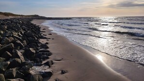 Una playa con costa rocosa y olas.