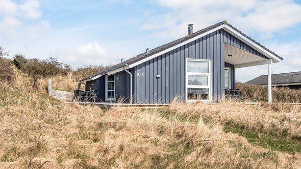 A modern house with a dark exterior, a covered porch, and a number '29' on the side. - 5 Star Holiday Home in Lokken (Lokken)