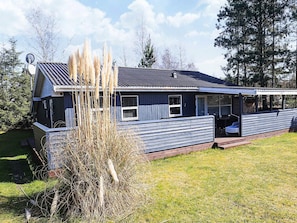 A single-story house with a covered porch, a satellite dish, and a small shed. - 4 Star Holiday Home in Vaeggerlose (Vaeggerlose)