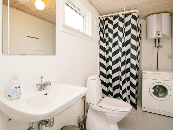 A bathroom with a white sink, toilet, and washing machine.