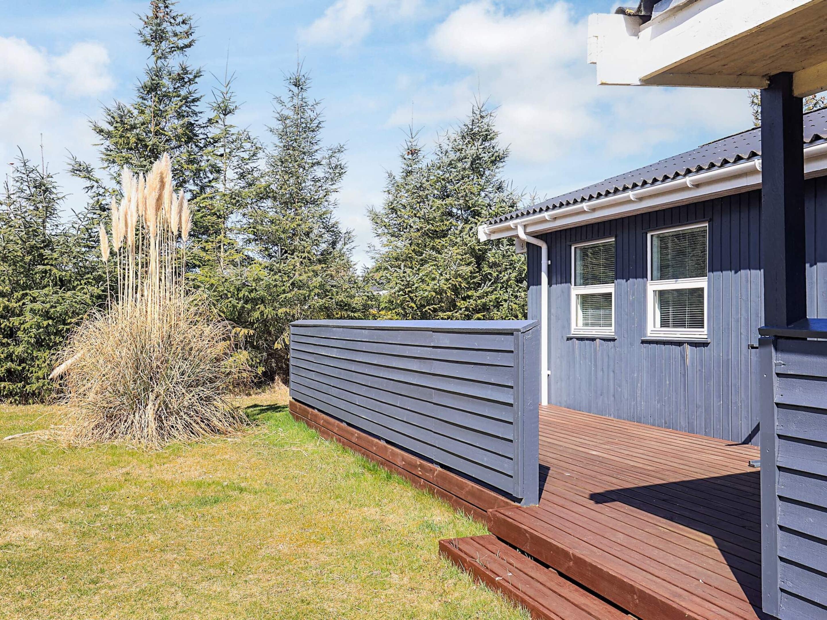 A blue building with a wooden deck and a window.