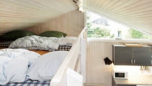 A compact bedroom with a bed, pillows, and a view of a house through a window. - 6 Person Holiday Home in Hejls-by Traum (Hejls)