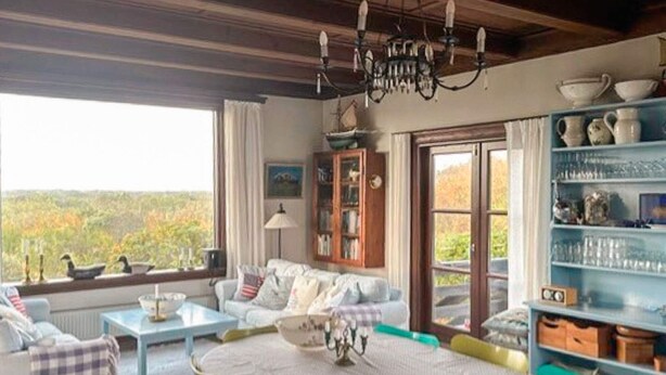 A cozy room with a dining table, chairs, a sofa, and a bookshelf. - Peaceful Holiday Home in Skagen near Sea (Skagen)