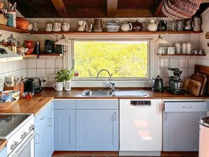 Une cuisine avec une fenêtre, un évier, une cuisinière et un lave-vaisselle.