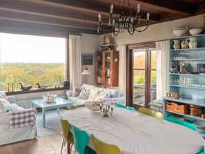 A dining area with a table, chairs, and a view of the outdoors.