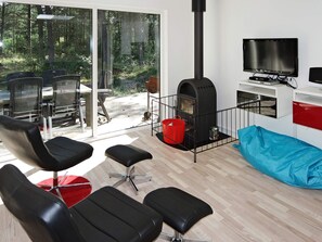A modern living room with a fireplace, seating area, and a TV.