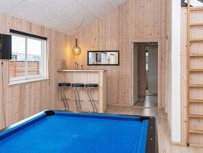 A pool table with three stools, a bar area with a mirror, and a window. - 5 Star Holiday Home in Nordborg (Nordborg)