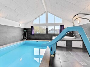 A swimming pool with a blue slide, a window, and a shower area. - 5 Star Holiday Home in Nordborg (Nordborg)