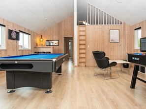 A pool table in a room with wooden walls and a staircase leading to an upper level. - 5 Star Holiday Home in Nordborg (Nordborg)