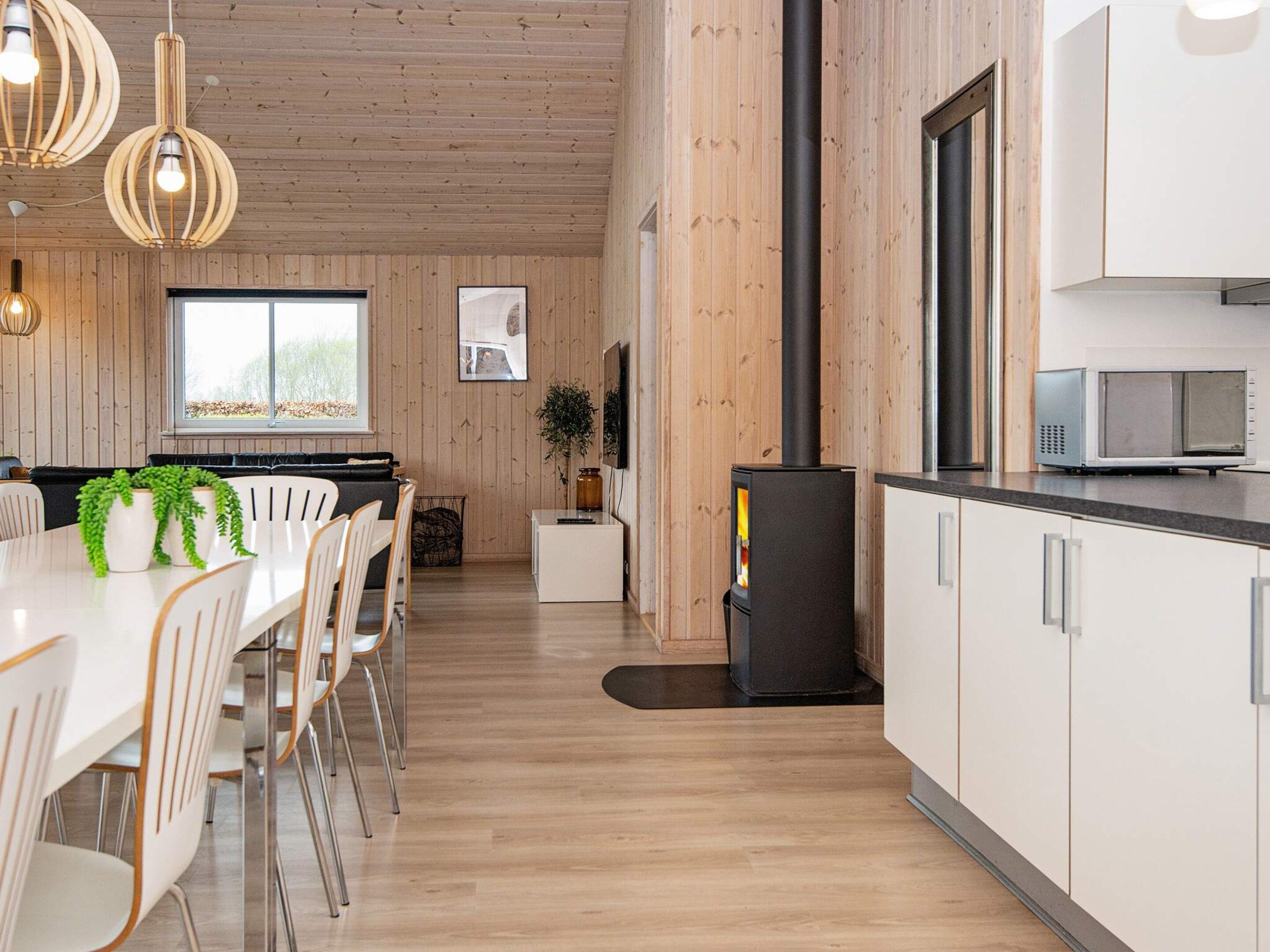 A modern kitchen with white cabinets, a black stove, and a microwave.