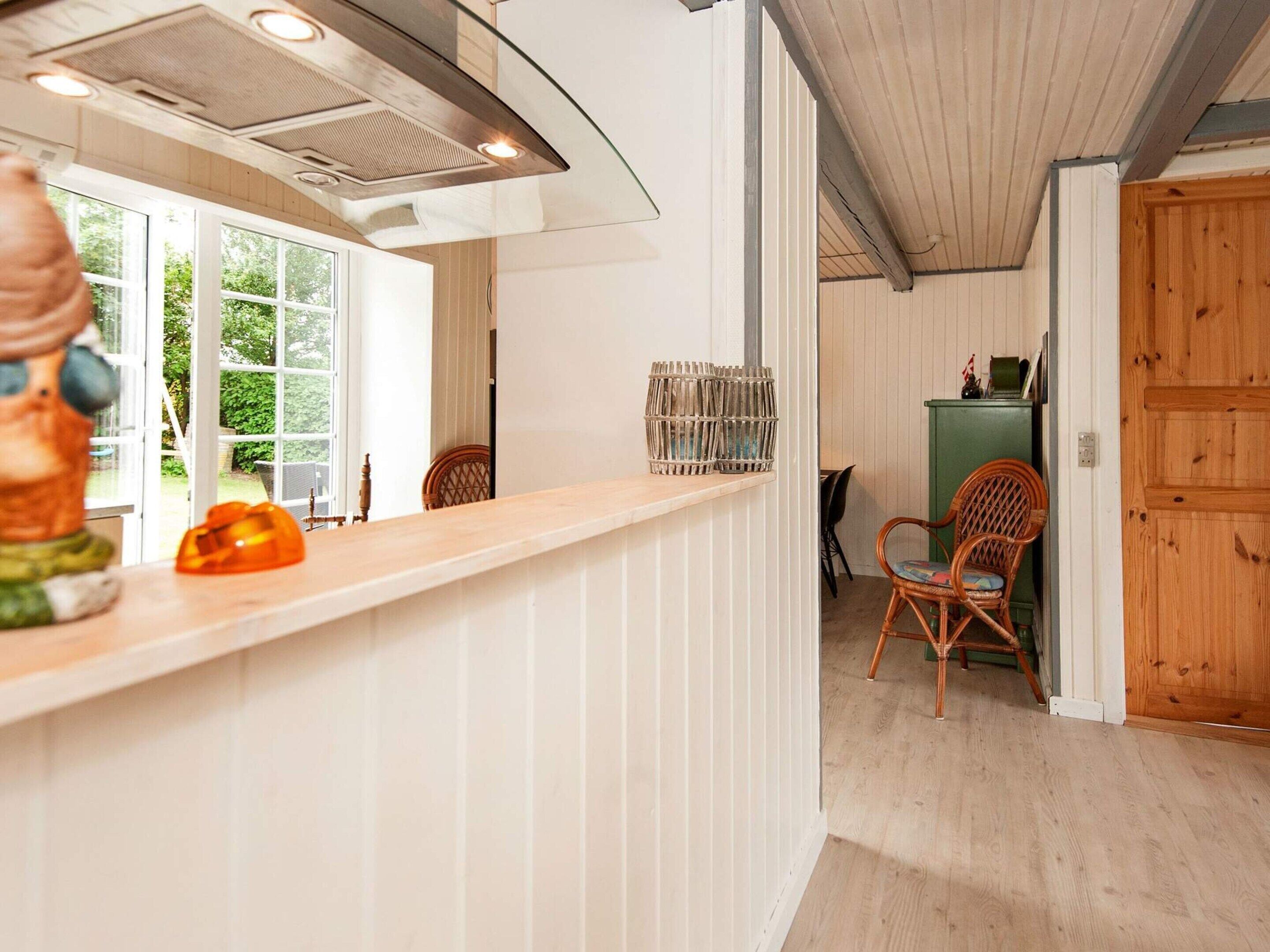 Una cocina con encimera de madera, una silla y un comedor con una silla y un armario.