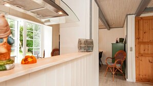 A kitchen with a wooden countertop, a chair, and a dining area with a chair and a cabinet. - 4 Person Holiday Home in Hejls (Hejls)