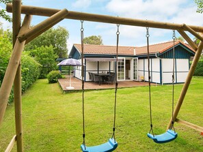 A wooden swing set with two swings in a backyard. - 4 Person Holiday Home in Hejls (Hejls)