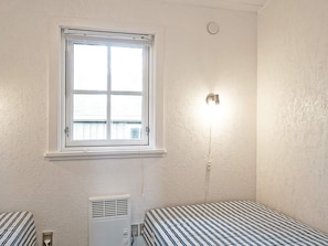 A room with a window, a wall-mounted light, and a heater. - 6 Person Holiday Home in Nexo (Nexø)