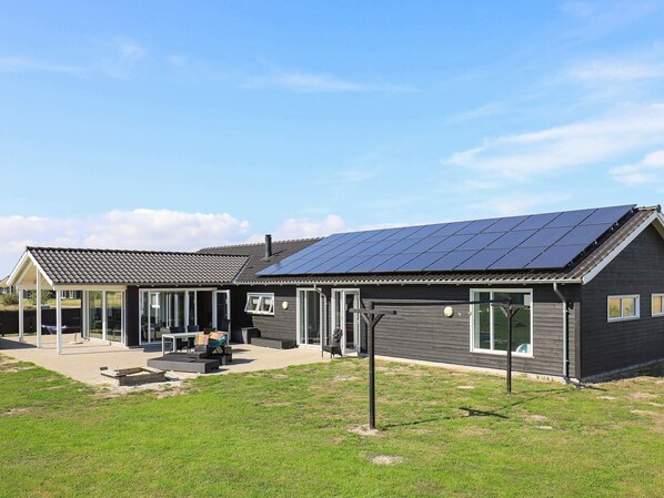 Un bâtiment moderne doté d’un toit en pente et de panneaux solaires.