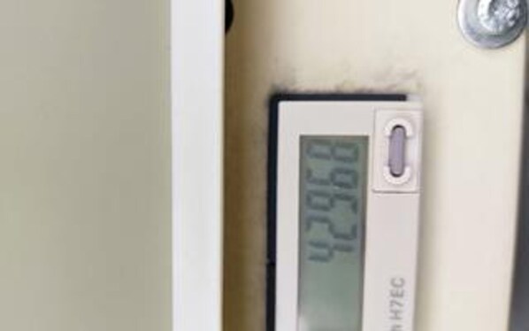 A thermostat with a digital display indicating a temperature of 42.36°C.