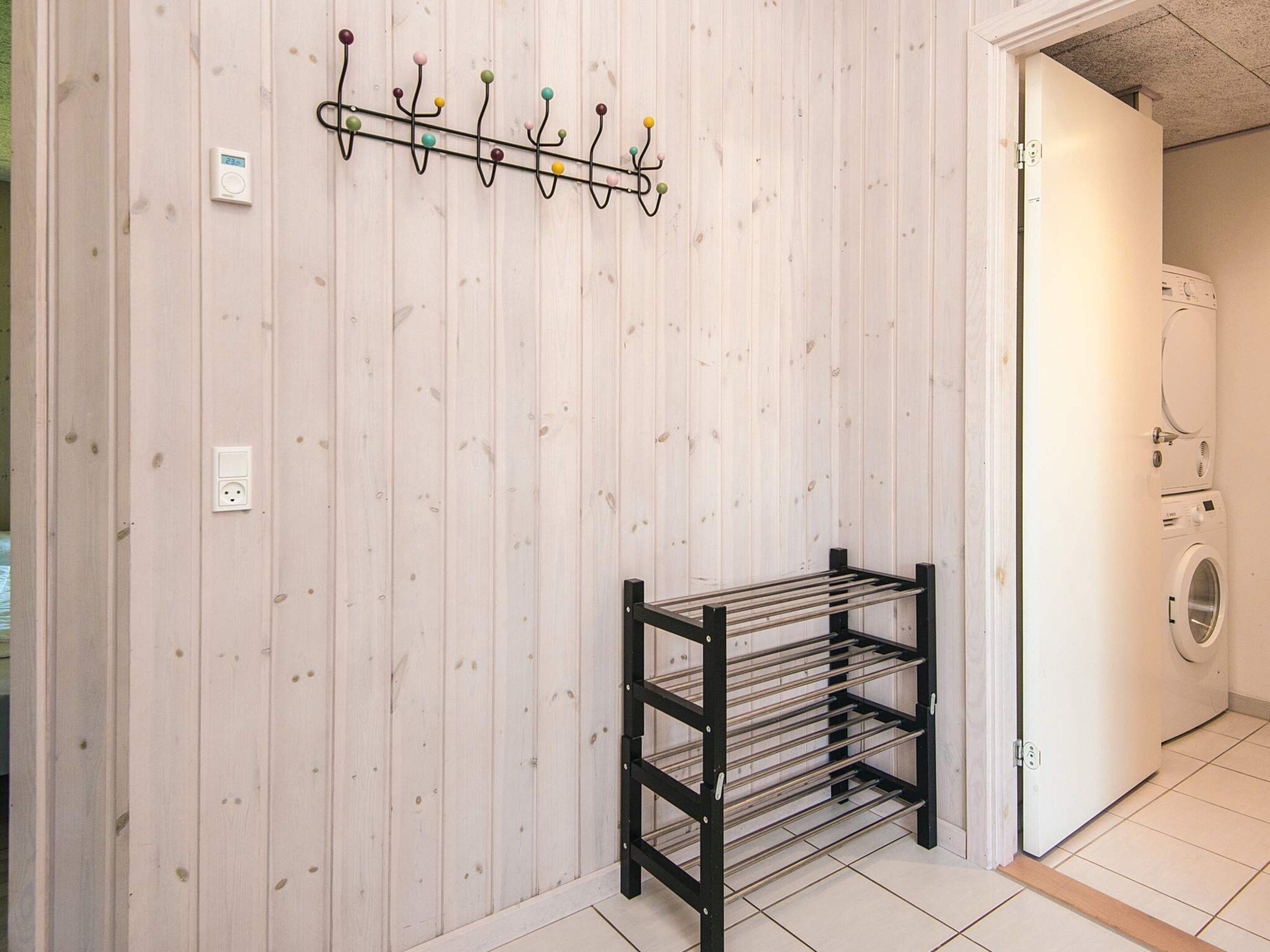 A laundry room with a drying rack and a wall-mounted coat rack.