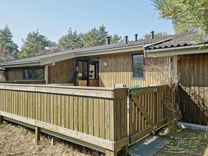 A wooden cabin with a deck, a door, and a window. - Cozy Holiday Home in Bornholm near Sea (Nexø)