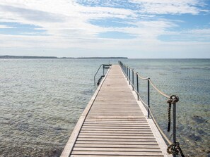 A wooden pier extending into calm water with a clear sky above. - 4 Star Holiday Home in Ebeltoft (Ebeltoft)