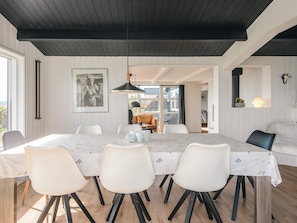 A dining area with a table, chairs, a pendant light, and a framed picture on the wall. - 4 Star Holiday Home in Ebeltoft (Ebeltoft)