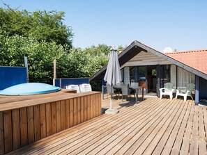 A wooden deck with a hot tub, outdoor seating, and a covered area with a view of the surrounding landscape. - 5 Person Holiday Home in Dannemare-by Traum (Dannemare)