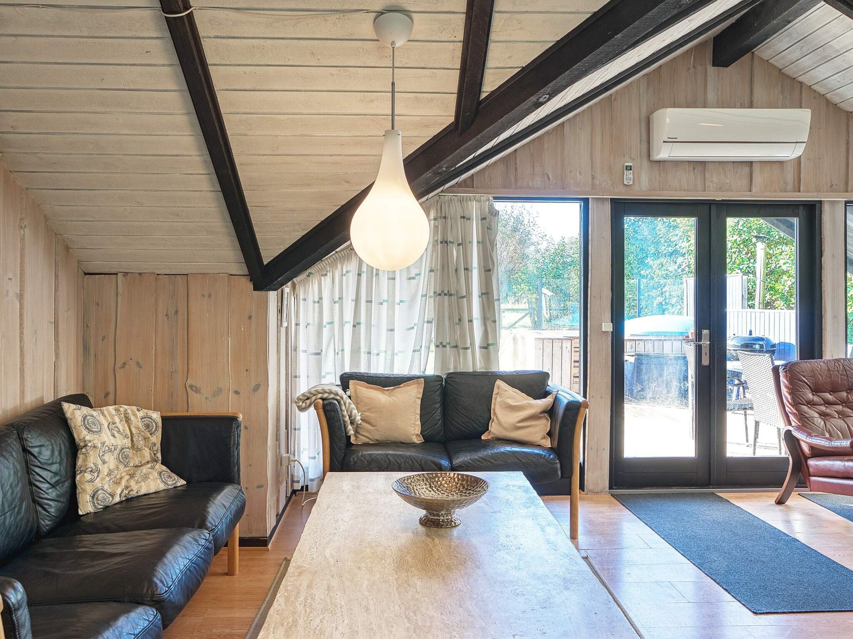 A modern living room with a sofa, a coffee table, and a leather armchair.