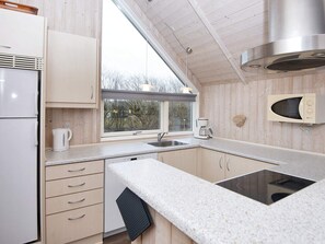Eine moderne Küche mit Einbauherd, Mikrowelle und einem Fenster für natürliches Licht.