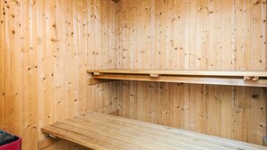 A wooden sauna room with benches and a shelf. - 8 Person Holiday Home in Ringkobing (Ringkobing)