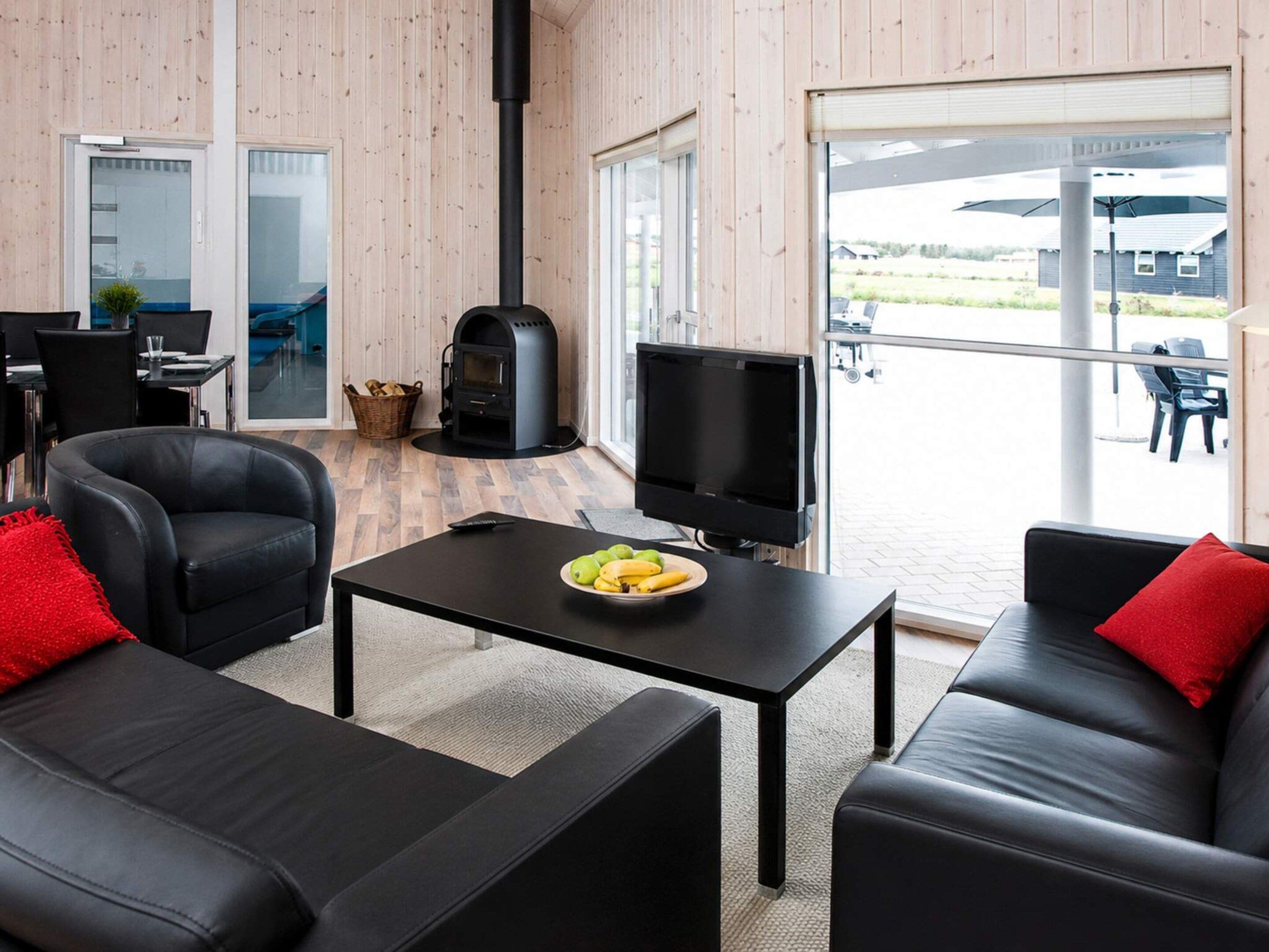 A modern living room with a fireplace, a television, and a dining area with a table and chairs.