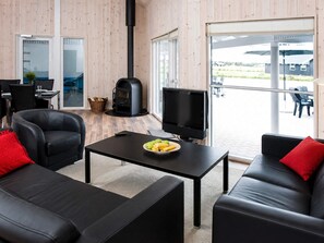 Una sala de estar moderna con chimenea, televisor y comedor con mesa y sillas.