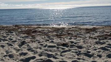A sandy beach with a clear view of the ocean.