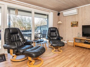 A modern living room with two leather recliners, a television, and a wooden floor. - 6 Person Holiday Home in Hemmet (Hemmet)
