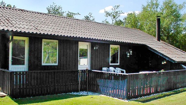 A wooden cabin with a porch, large windows, and a chimney. - 6 Person Holiday Home in Hemmet (Hemmet)